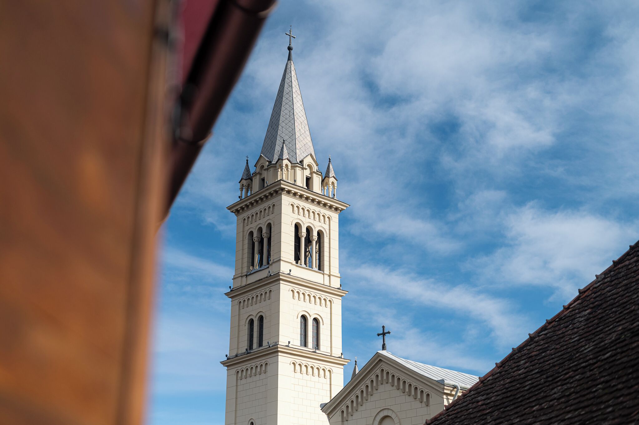 Una chiesa con un campanile alto e una guglia.