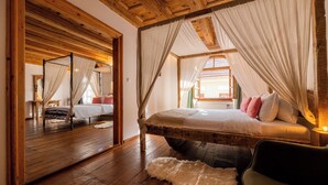 A bedroom with a wooden ceiling, a large bed with white bedding, and a mirror on the wall. - Boutique Hotel von Graf (Sighisoara)
