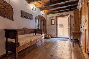 A rustic room with a wooden bench, a mirror, and a radiator. - Boutique Hotel von Graf (Sighisoara)