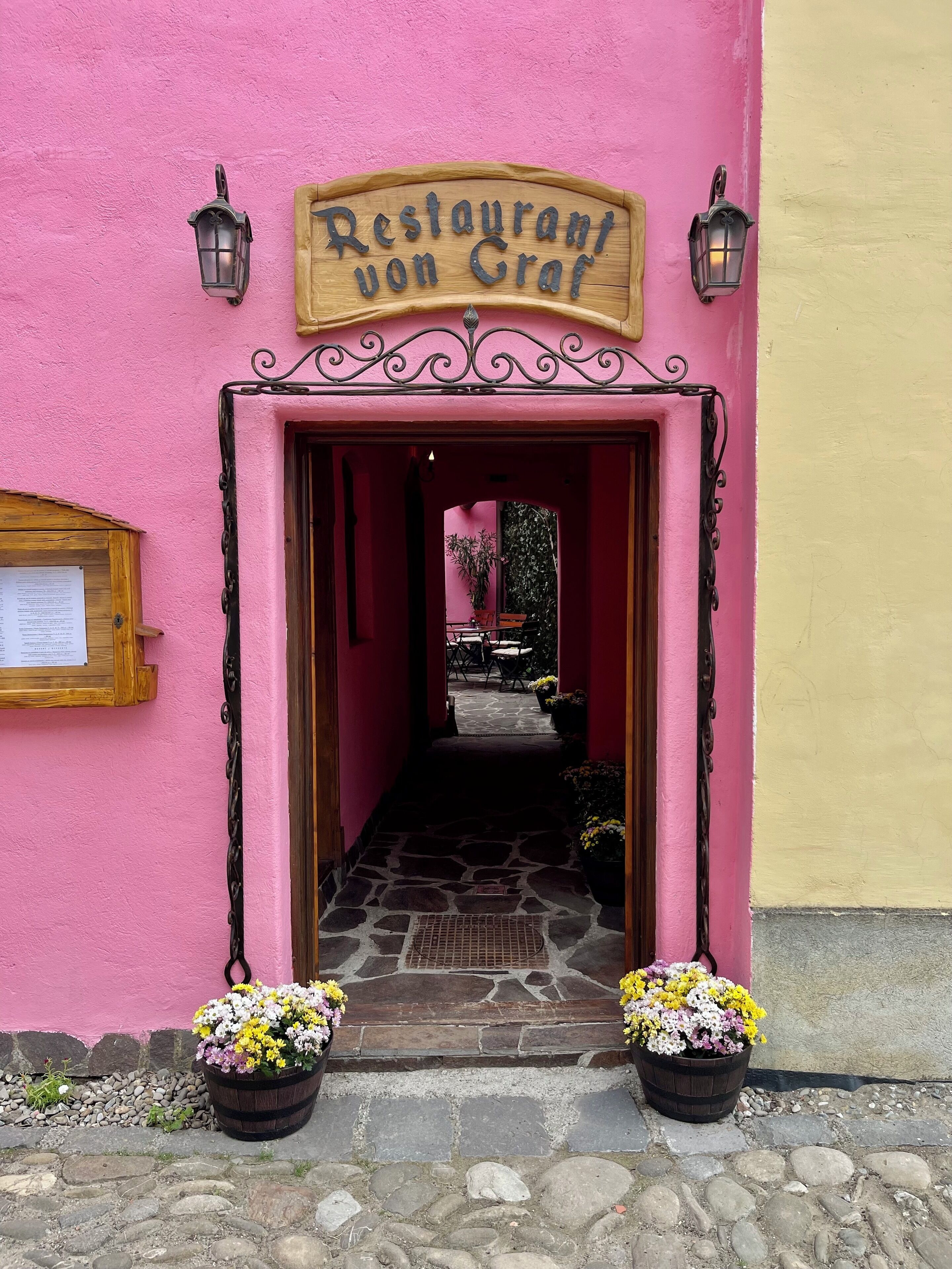 A pink building with a wooden sign reading "Restaurant von Graf" above the entrance.