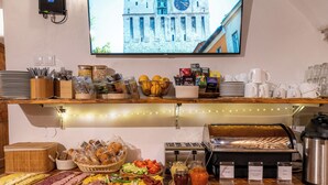 A buffet setup with various food items, utensils, and condiments. - Boutique Hotel von Graf (Sighisoara)