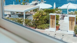 Un puerto deportivo con barcos, una zona de estar cubierta y plantas en macetas.
