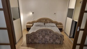 A bedroom with a bed, a nightstand, and a dresser.
