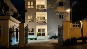A multi-story building with a central entrance, balconies, and a gated driveway. - Wellaton Suite (Abuja)