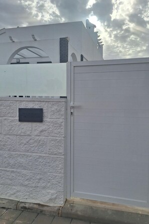 A gated entrance with a white wall and a metal gate. - Luxurious Villa La Vita e Bella Escape in Murcia (Murcia)