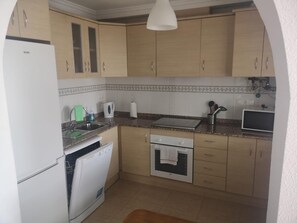A compact kitchen with a dishwasher, oven, and a microwave. - Luxurious Villa La Vita e Bella Escape in Murcia (Murcia)