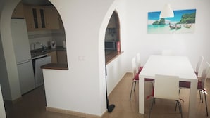 A modern kitchen with a built-in oven and a dining area with a white table and chairs. - Luxurious Villa La Vita e Bella Escape in Murcia (Murcia)