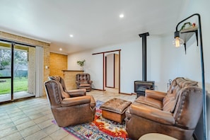 A living room with leather sofas, a fireplace, and a large window.