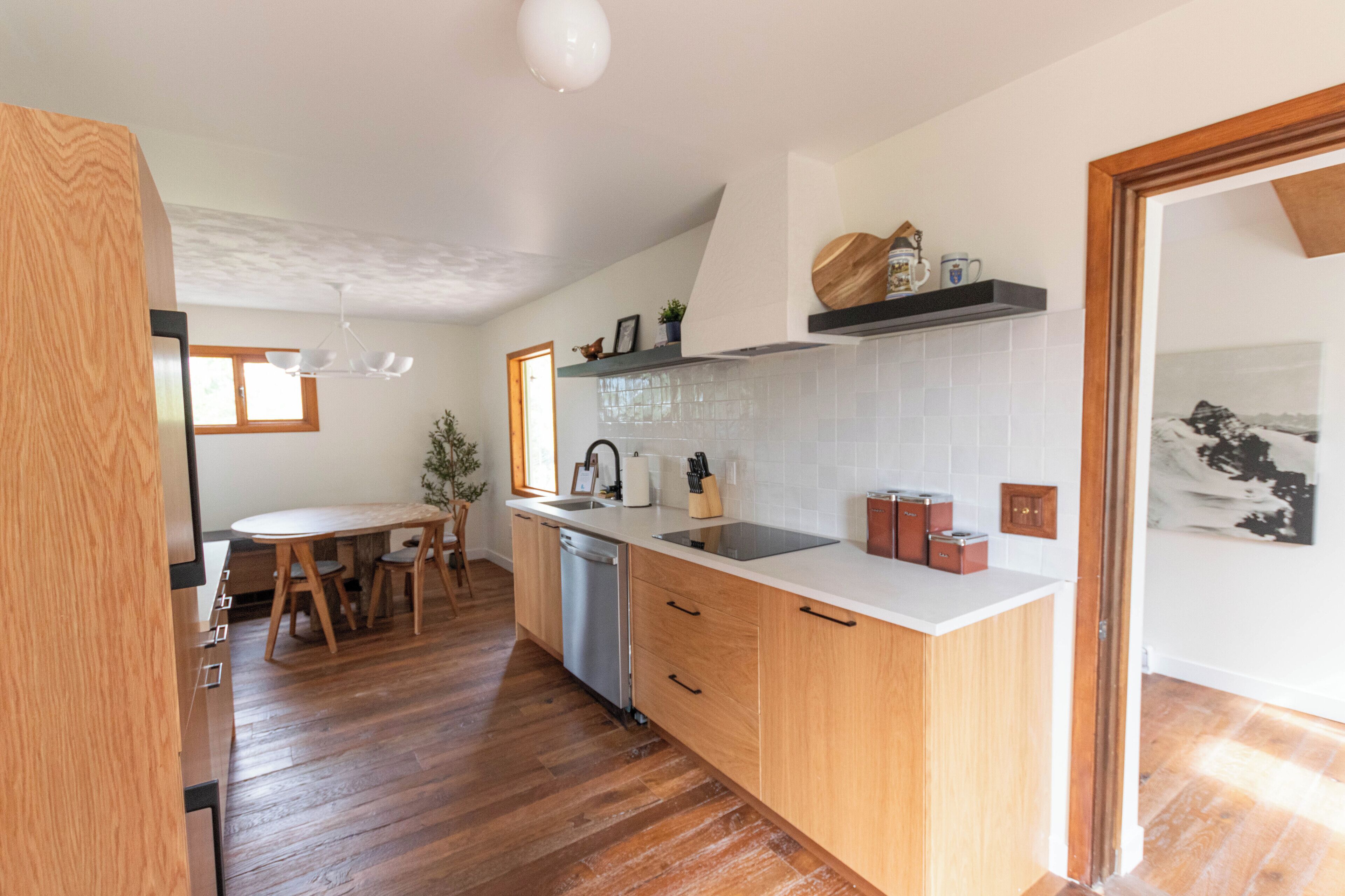 Een moderne keuken met houten kastjes, een wit aanrecht en een inbouwvaatwasser.
