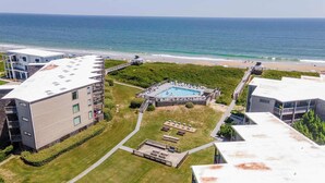 A residential building with a swimming pool, a beach, and a clear view of the ocean. - In Duck with Community Pool & Beach Access (Duck)