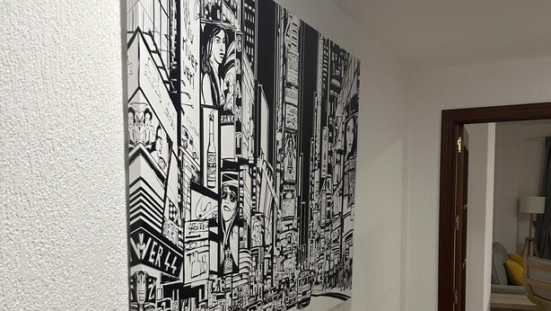 A large black and white cityscape mural on a plain wall.