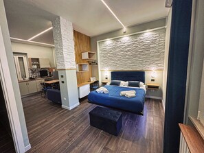 A modern hotel room with a large bed, a desk, and a kitchenette. - Central Vasto Histonium (Vasto)