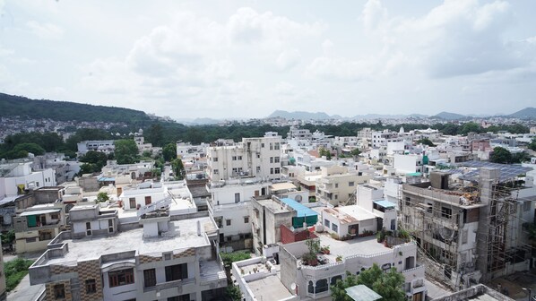 A densely packed urban area with multi-story buildings, some with visible satellite dishes and solar panels. - Hotel Lake Metro (Udaipur)