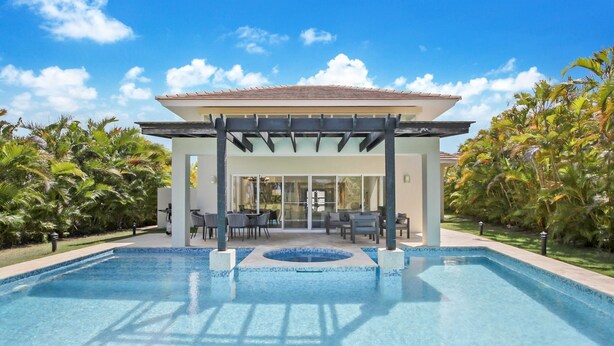 A pool area with a covered seating area, surrounded by palm trees. - Luxury Golf Villa in Bavaro Cocotal Palma Real Pool Jacuzzi Staff (Punta Cana)