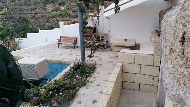 A rooftop terrace with a wooden pergola, a bench, a small table, and a concrete planter with flowers. - CASAPANCHO 3 (CN)