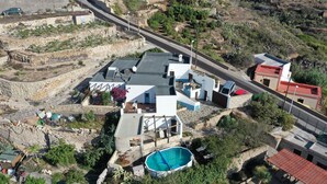 An aerial view of a residential area with houses, a swimming pool, and a road. - CASAPANCHO 3 (CN)