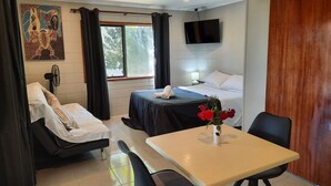 A hotel room with a bed, a desk, a chair, a TV, and a painting on the wall. - Three Falls Holiday Millaa Millaa waterfall circuit. Famous Millaa Milllaa Fall  (Millaa Millaa)