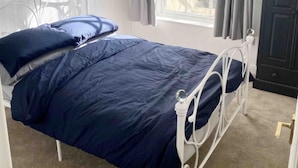 A bedroom with a single bed, a window with curtains, a dark wardrobe, and a wall-mounted artwork. - Torquay, 1 Bedroom, Sleeps 4, Free Parking, Torbay (Torquay)