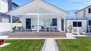 A modern house with a covered patio, a dining area, and a pool. - La Palma Beach House ~ Charming coastal retreat (Warilla)