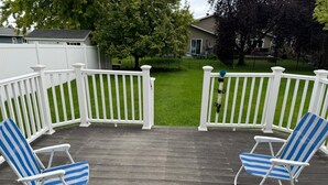 Une terrasse en bois avec deux chaises de jardin à rayures bleues.