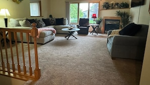 Un salon comprenant un canapé, un fauteuil, une table basse et une cheminée.