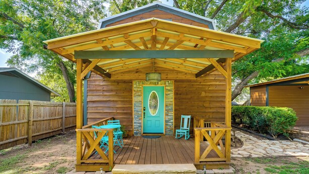 A wooden cabin with a porch, a door, and a welcome mat. - Pet-friendly Granbury Home w/ Yard, Near Downtown! (Granbury)