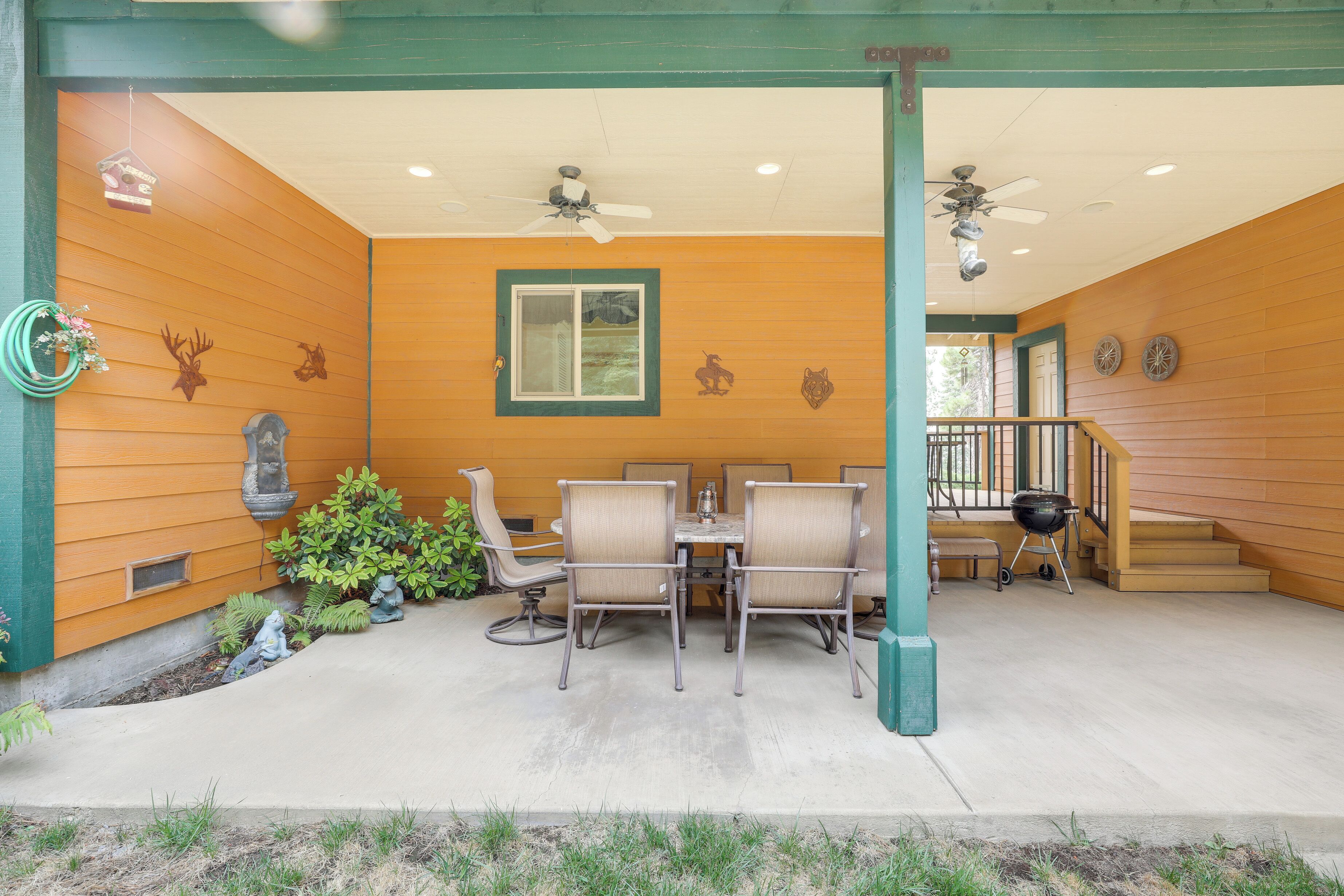 An outdoor patio with a table and chairs, a ceiling fan, and a barbecue grill.