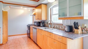 A kitchen with wooden cabinets, a stainless steel sink, and a window above the countertop. - Pet-friendly New Berlin Retreat w/ Patio & Yard! (New Berlin)