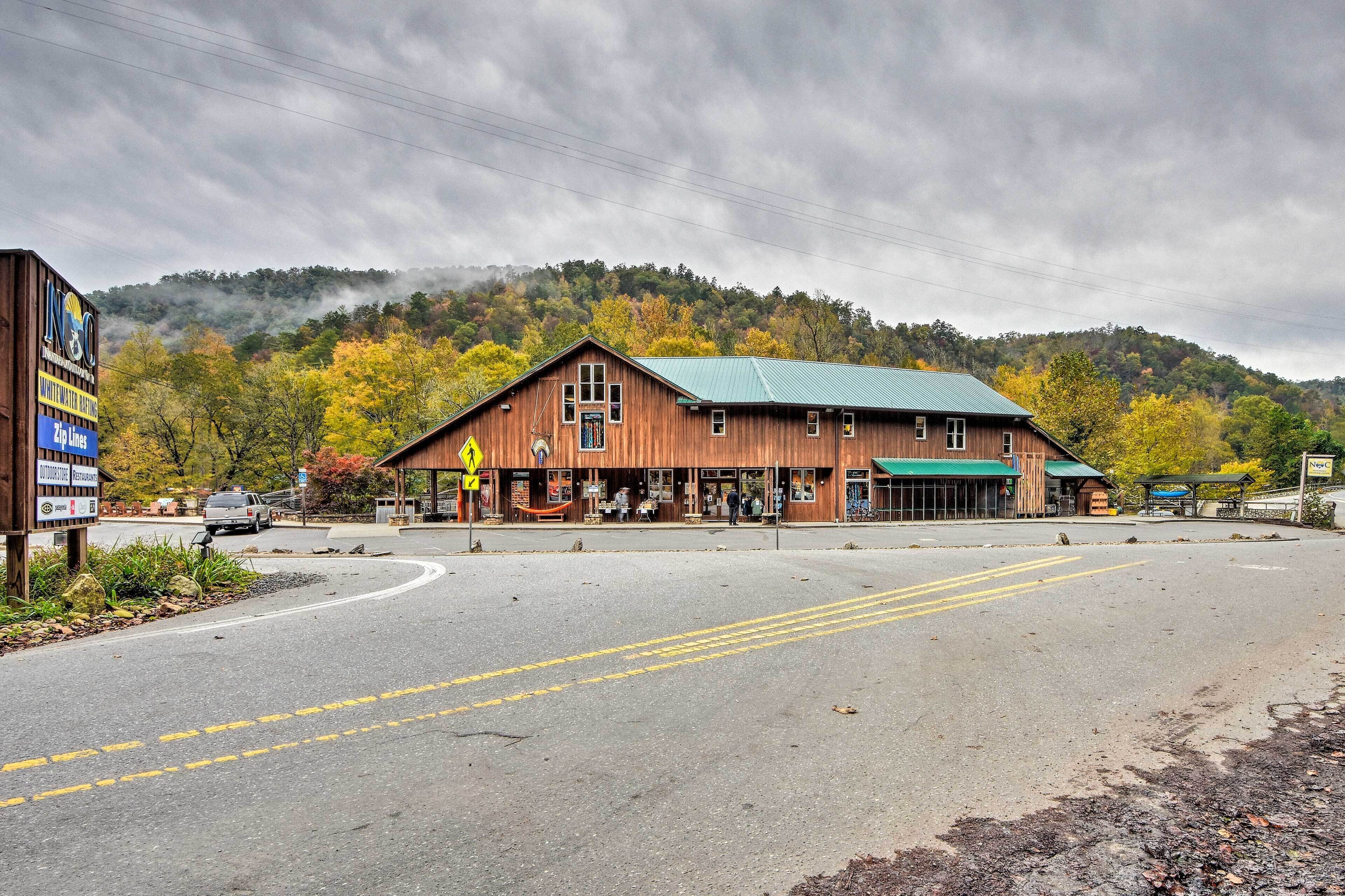 Un bâtiment en bois avec un toit végétalisé, une enseigne et une route devant.