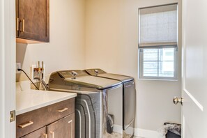 A laundry room with a washing machine, dryer, and wooden cabinets. - Park City Home w/ Game Room: Ski, Mtn Bike & More! (Park City)