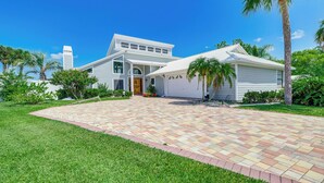 A two-story house with a large front porch, a garage, and a well-maintained lawn. - Boat Dock & Pool: Bayfront Crystal River Home (Crystal River)