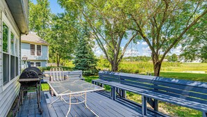 A deck with a grill, table, and benches, surrounded by trees and a house. - 14 Mi to Lucas Oil Stadium: Fire Pit & Grill! (Indianapolis)