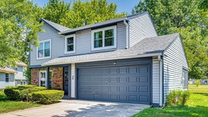 A two-story house with a garage, a front door, and a small front yard with trimmed bushes. - 14 Mi to Lucas Oil Stadium: Fire Pit & Grill! (Indianapolis)
