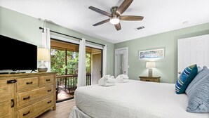 A bedroom with a bed, a TV, a ceiling fan, a nightstand, and a view of the outdoors. - 2Br/2.5Ba, 2 Pools, Tennis, Beach Access! + Free Attraction Tickets! (Santa Rosa Beach)