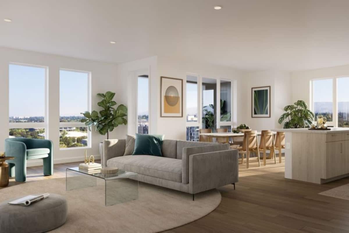A spacious living room with a sofa, coffee table, and a view of the city.