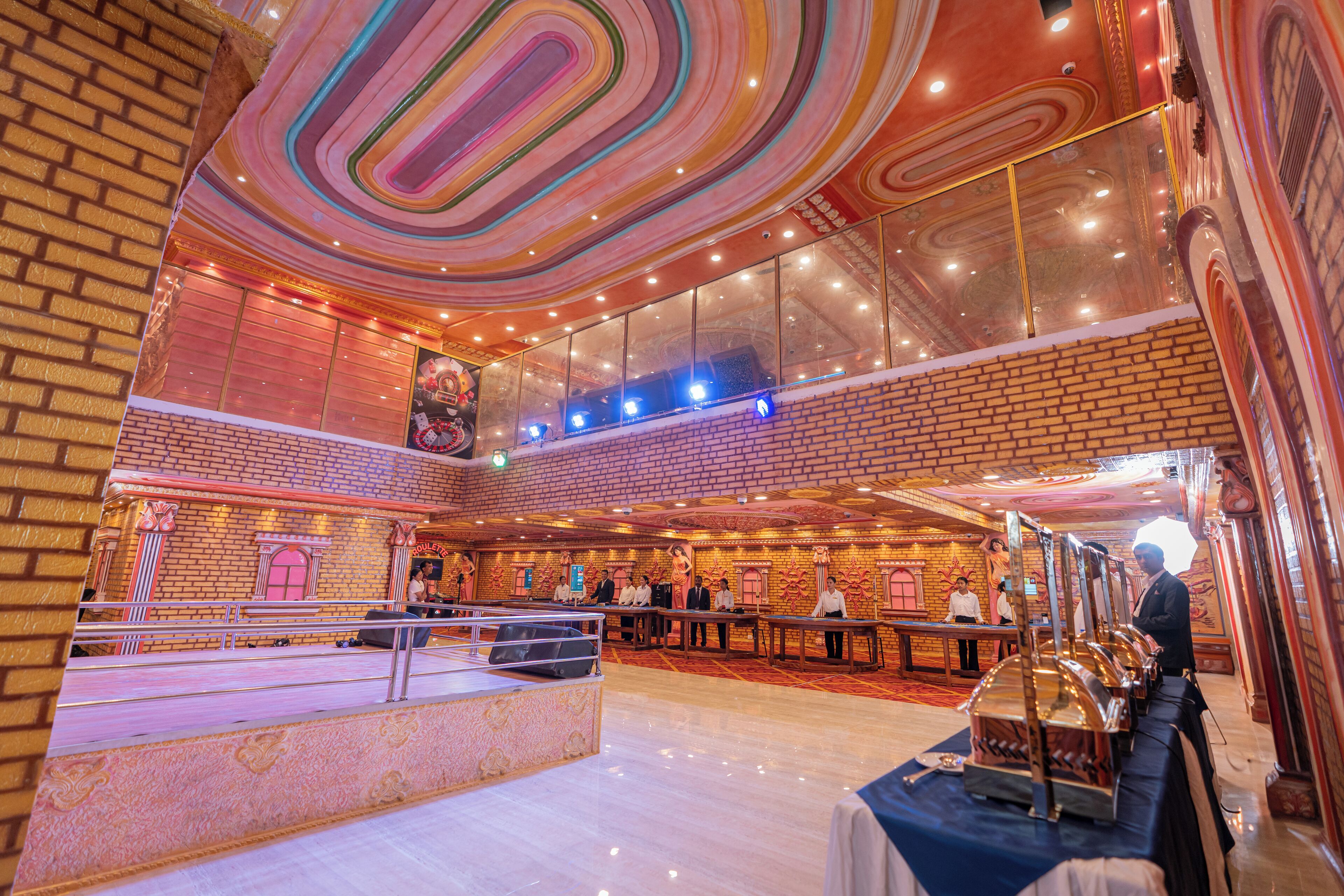 A spacious hall with a high ceiling, brick walls, and a stage area.