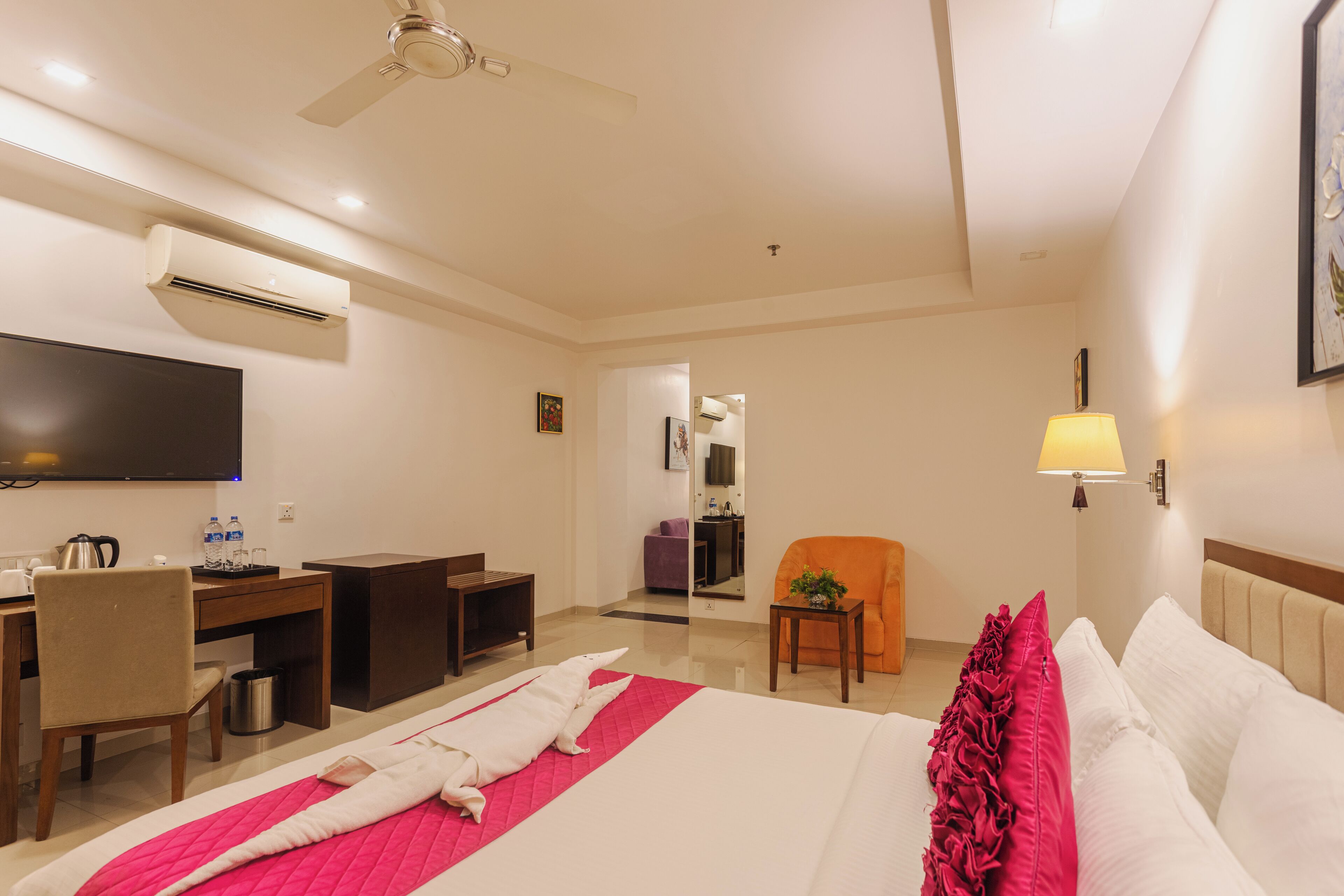 Une chambre d’hôtel équipée d’un lit, d’un bureau, d’une chaise et d’un téléviseur.