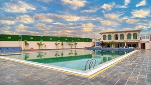 Una piscina con cielo azul despejado y nubes al fondo.