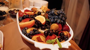 A fruit platter with various fruits including grapes, cherries, and apples. - Skala (Burabay)
