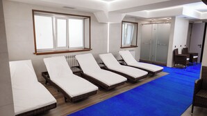A room with five sunbeds aligned against the wall, a radiator, and a blue carpet. - Skala (Burabay)
