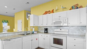 A kitchen with white cabinets, a microwave, an oven, and a coffee maker. - Dream Chaser, Private Pool, Hot Tub, Pet Friendly (Eastpoint)