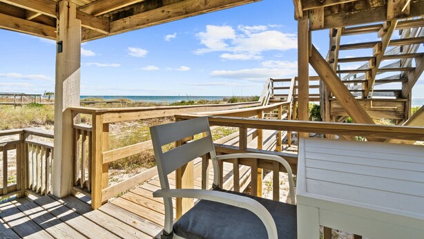 A wooden deck with a view of the beach and ocean. - Sunflower 3, Pet friendly, Beachfront. (Eastpoint)