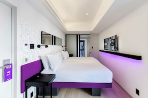 A modern hotel room with a large bed, a bedside table, a mirror, and a wall-mounted shelf. - YOTEL Tokyo Ginza (Tokyo)