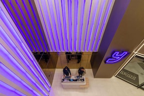 A modern interior with a reception desk, vertical lighting, and a visible logo. - YOTEL Tokyo Ginza (Tokyo)