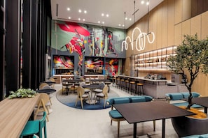 A modern restaurant with a bar area, seating arrangements, and a large abstract mural on the wall. - YOTEL Tokyo Ginza (Tokyo)