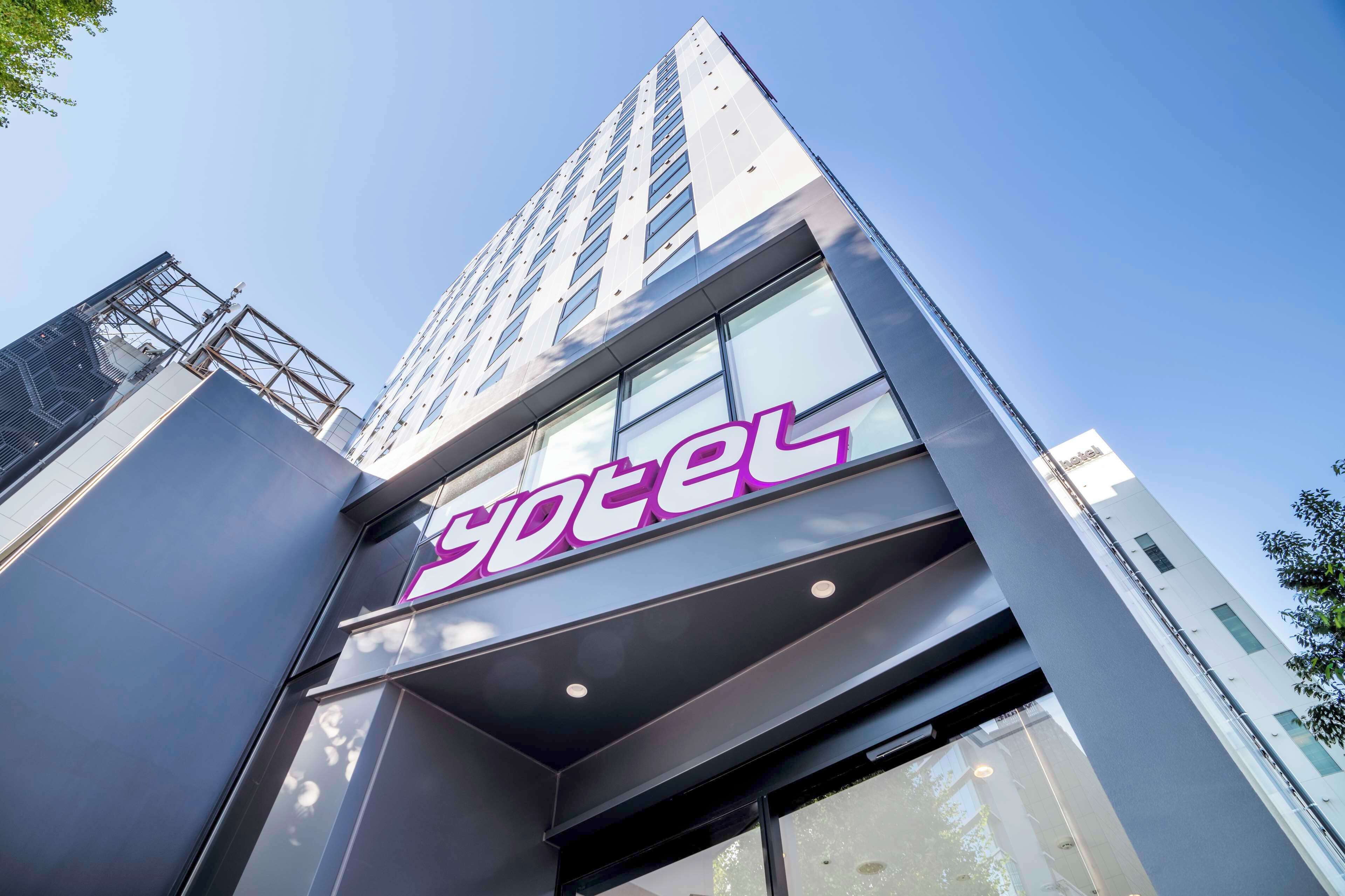 A modern hotel building with a prominent 'hotel' sign.