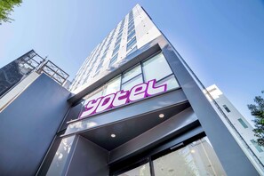 A modern hotel building with a prominent 'hotel' sign.