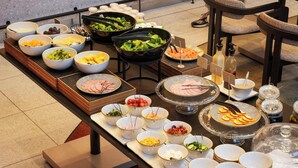 A buffet table with various food items and condiments. - YOTEL Tokyo Ginza (Tokyo)