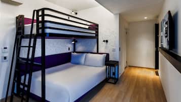 A bunk bed with a ladder, a bedside table, and a wall-mounted TV.