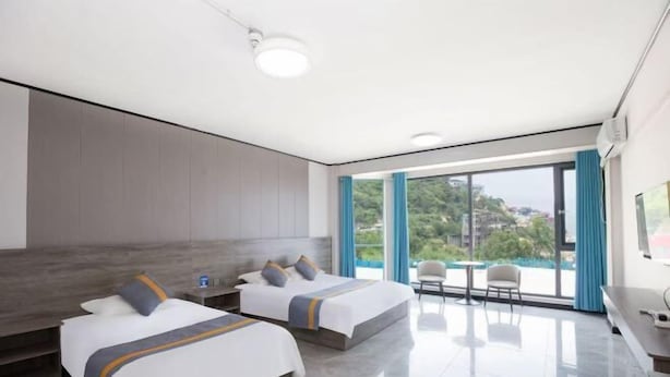 A modern hotel room with two beds, a balcony with a view, and a flat-screen TV. - Lianyungang Liandao Yanyangtian Holiday Center (Lianyungang)